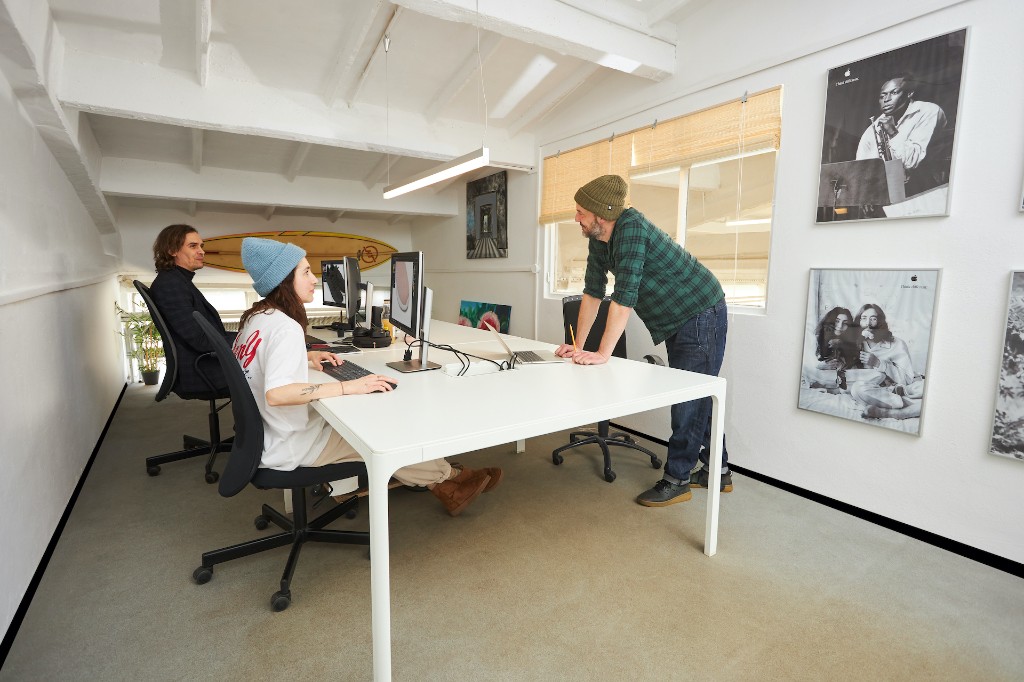 The EVG creative team in the agency space connected to the studio — working at monitors on brand assets
